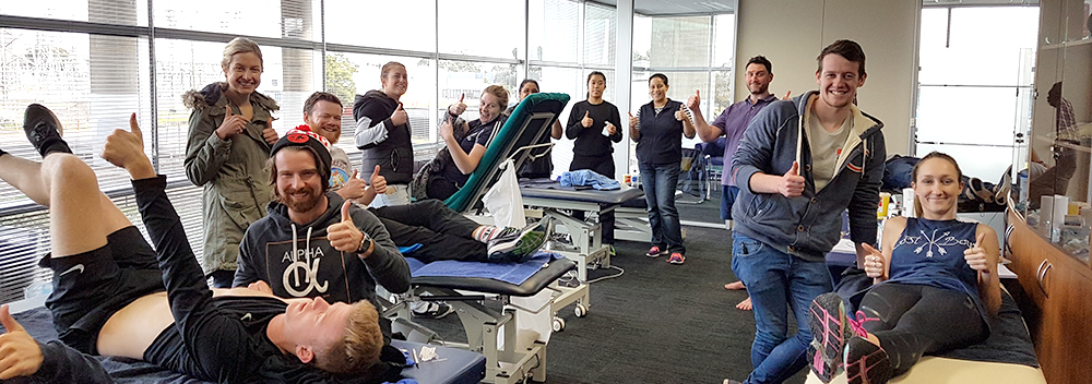 Group of healthcare students in scrubs training around a table